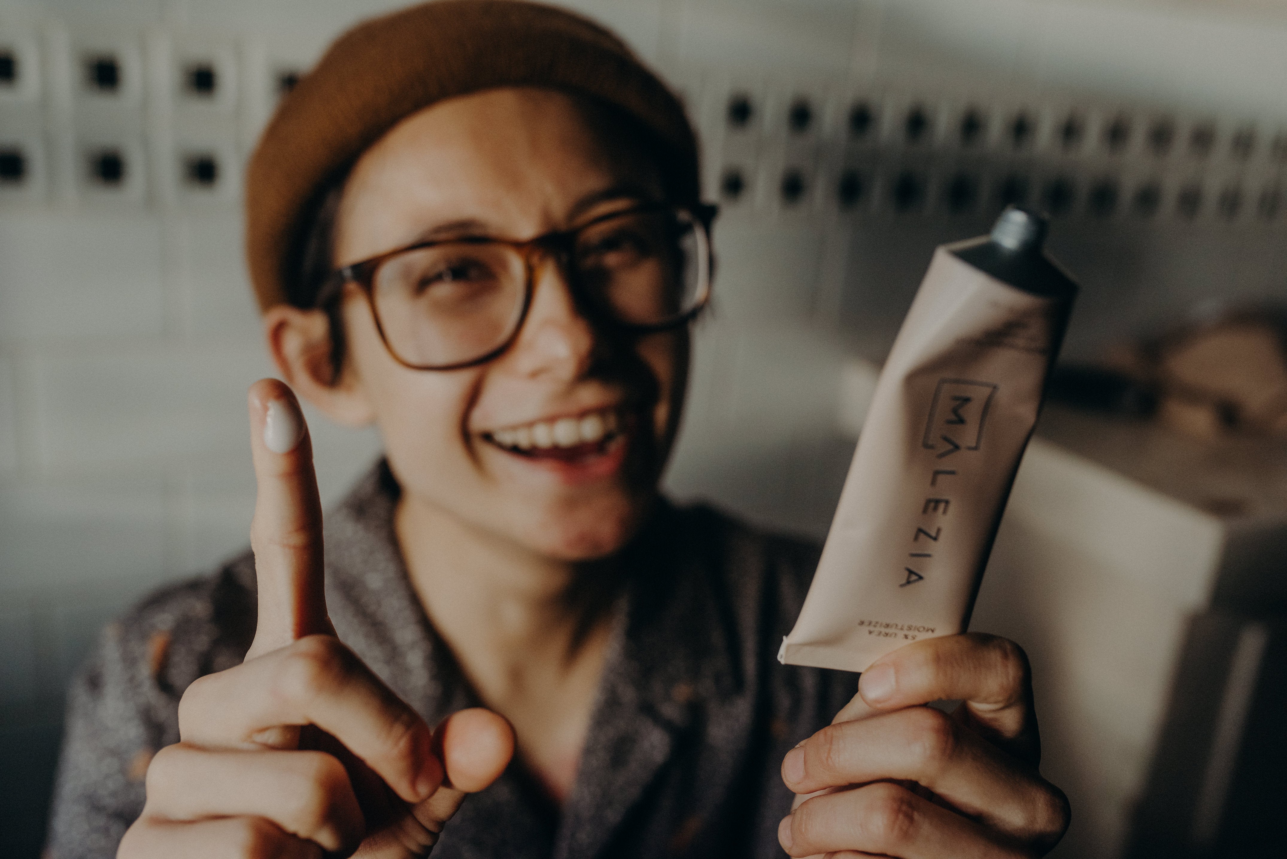 A friend of Malezia smiling with a dab of 5% Urea Moisturizer on their finger